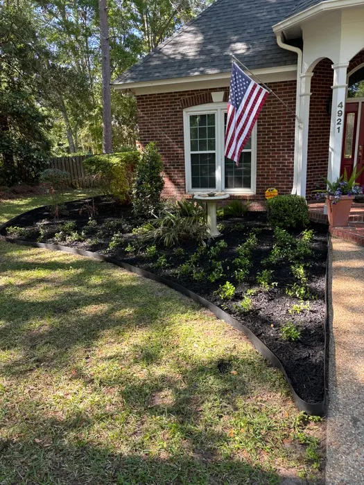 Front bed at a brick home cleared and topped with black dyed mulch, new edging and small new shrubs